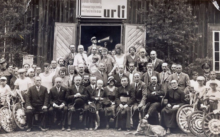 Zdjęcie z dnia 6 lipca 1930 roku. W pierwszym rzędzie pierwszy po lewej Roman Pawelski. W sutannie z medalem na piersi Ksiądz Prałat Michalski, obok niego z przepaską na czole Eugeniusz Pietrzykowski – sekretarz Stowarzyszenia Przyjaciół Miłośników Urli, po prawej miejscowy ksiądz Białko, a za nim w garniturze Stanisław Życki