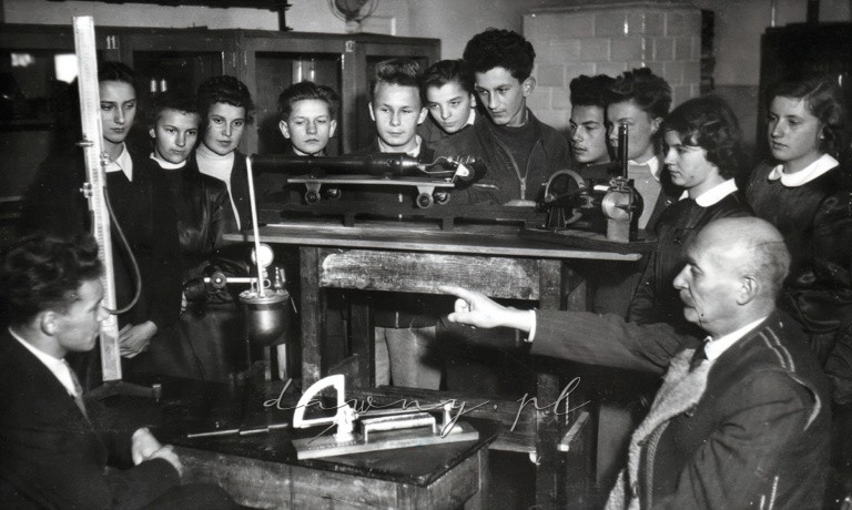 Rok 1957. Prof. Adam Milewski i grupa młodzieży z klasy IXb w gabinecie fizycznym.