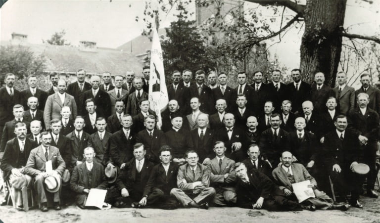 Katolickie Stowarzyszenie Męskiejako jedna z organizacji dzialajacych przy parafii pw. Św. Izydora - Oracza w Markach.. W środku przy sztandarze proboszcz ks. Teodor Jesionowski. Fot. lata 30 XX w.