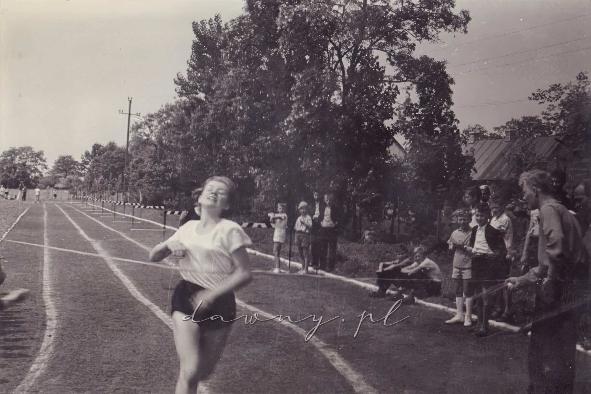 100 metrów dziewcząt, druga seria. Finiszuje Ela Dzbeńska. Kronika I LO w Wołominie, rok 1964.
