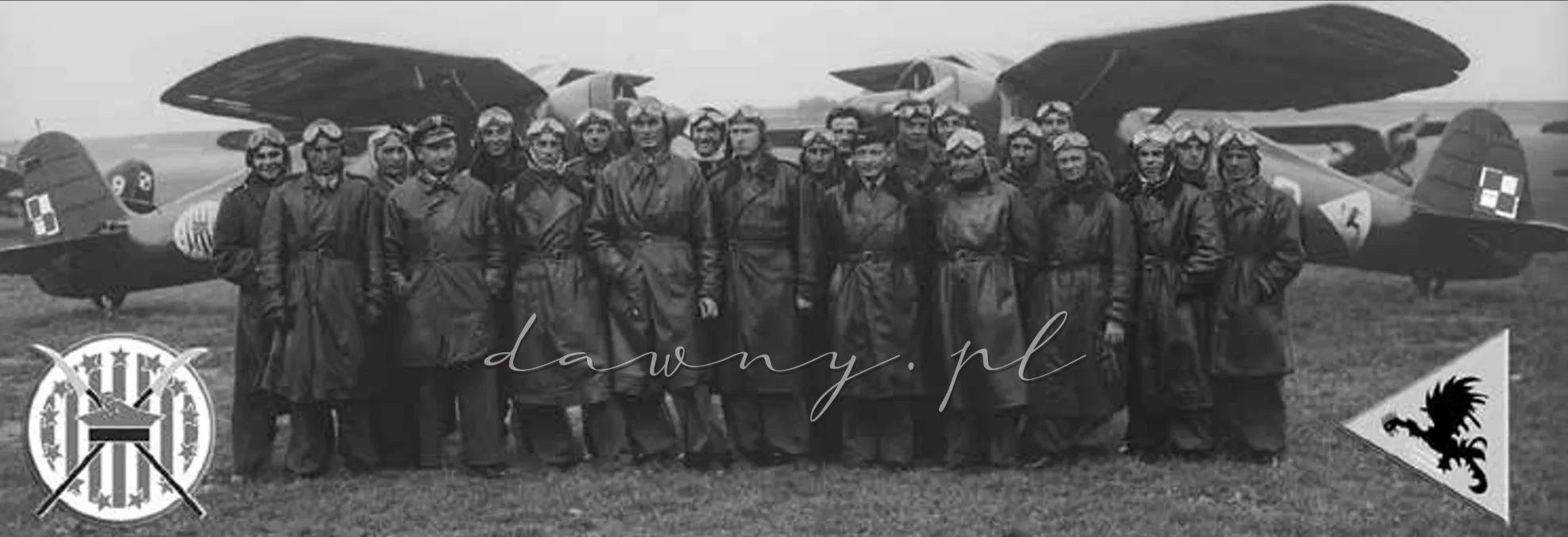 Piloci III/1 Dywizjonu Myśliwskiego, sfotografowani w październiku 1938 r. na lotnisku Aleksandrowice podczas operacji na Zaolziu. W tle po lewej P.11c ze 111 eskadry oraz po prawej P.11c ze 112 eskadry. Od prawej, 3-ci – por. pil. Wojciech Januszewicz ostatni dowódca 111 EM, 7-my dowódca 112 EM kpt. pil. Tadeusz Opulski. Od lewej 5-ty por. pil. Stefan Okrzeja, 8-my – dowódca 111 EM do 1.09.1939 - kpt. pil. Gustaw Sidorowicz